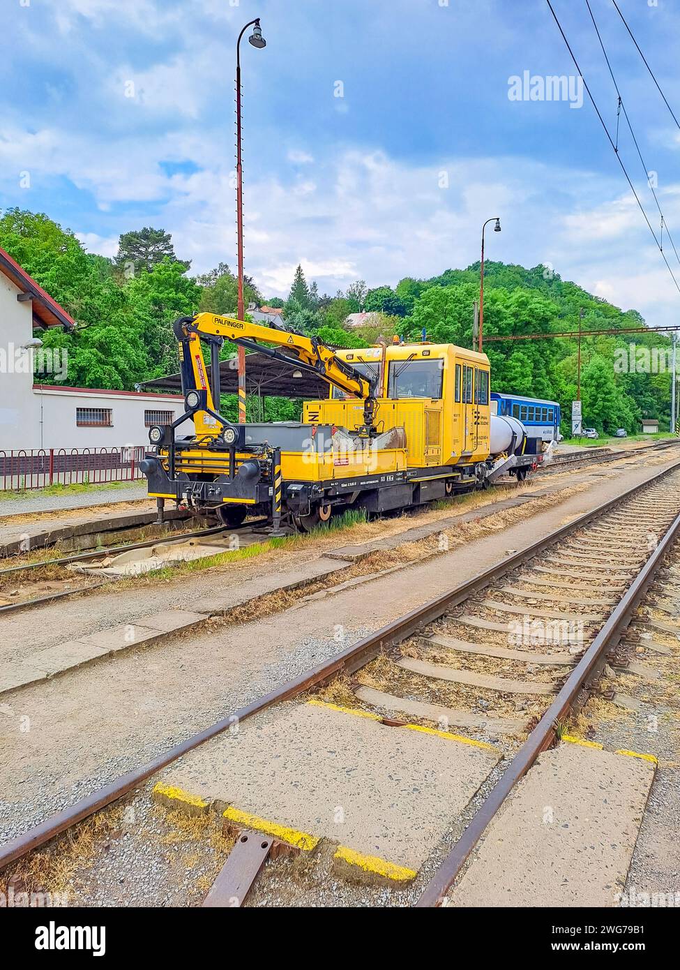 Excavator yellow on the railway track of the Czech Republic. Zadni Treban. Stock Photo