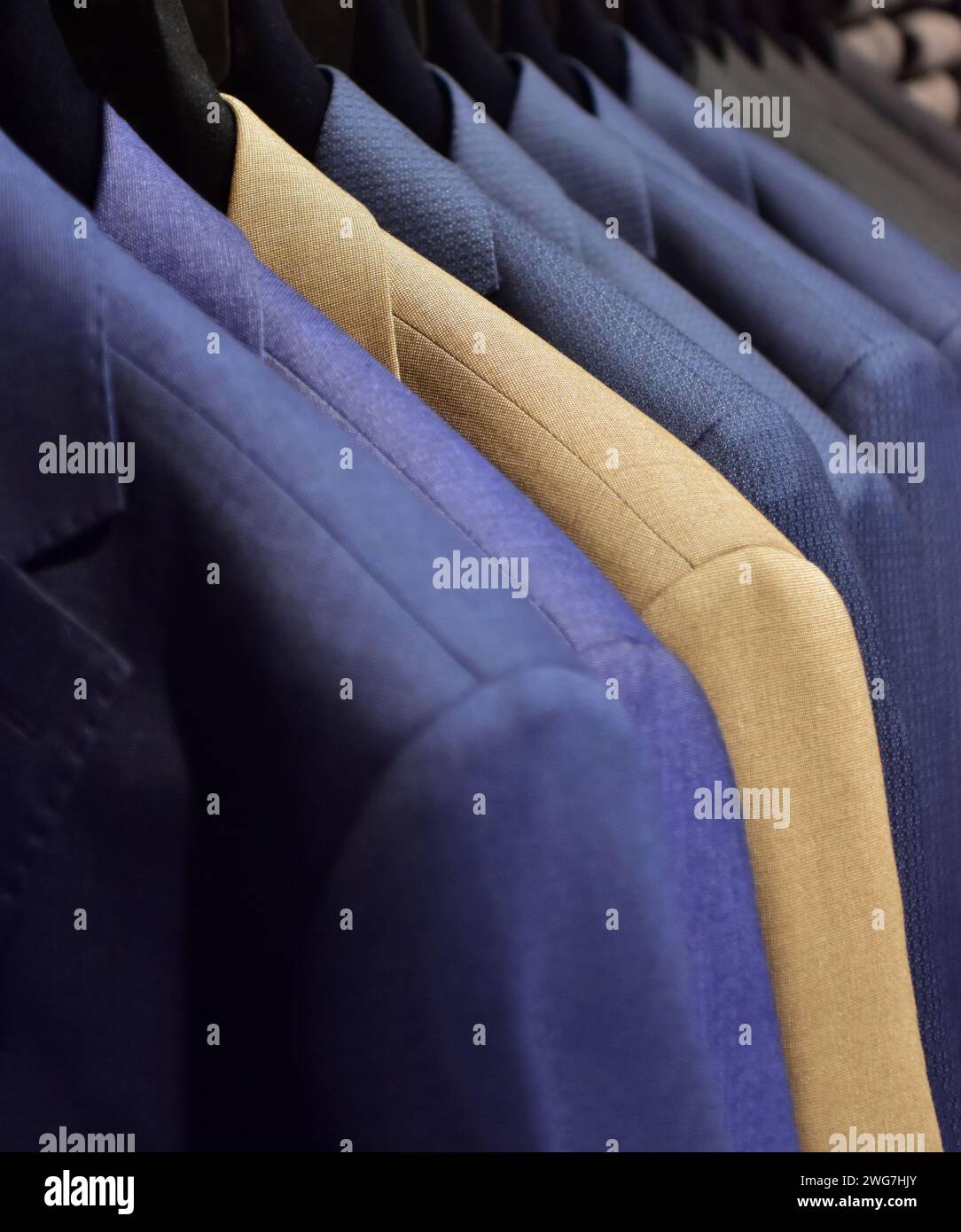 Suits on a clothing hanger in a boutique. Stock Photo