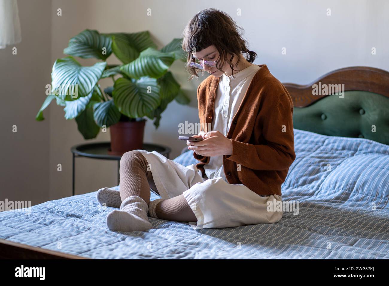 Rejected teenage girl obsessed with mobile phone, spends time at home, feeling lonely, unhappy Stock Photo