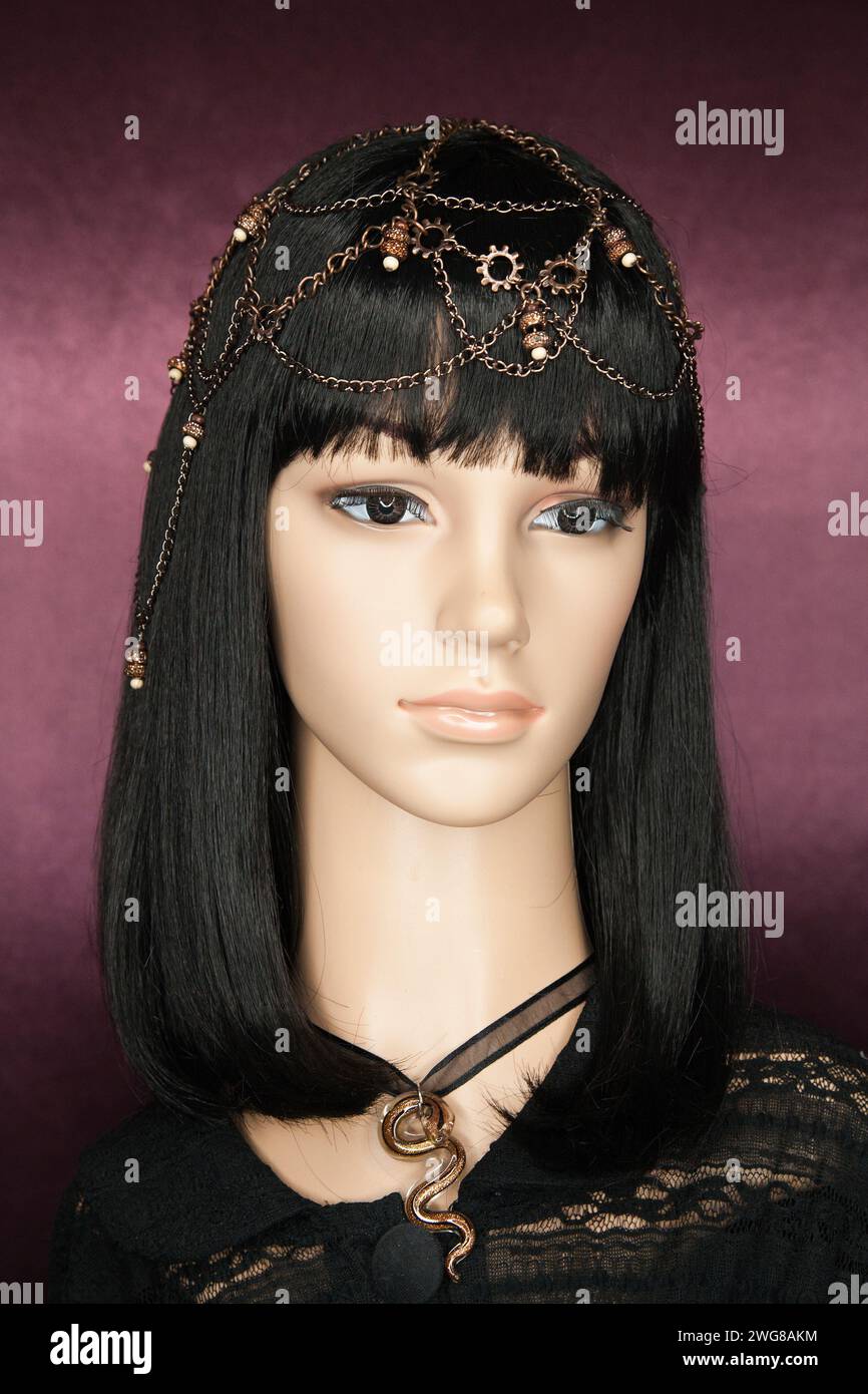 Plastic woman mannequin with long black hair wearing a chain head piece