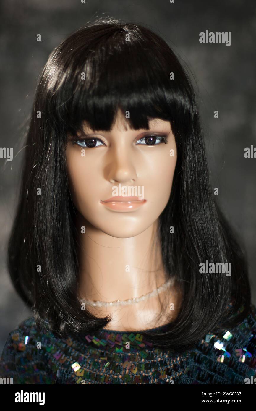 Plastic woman mannequin with long black hair wearing a sequins top