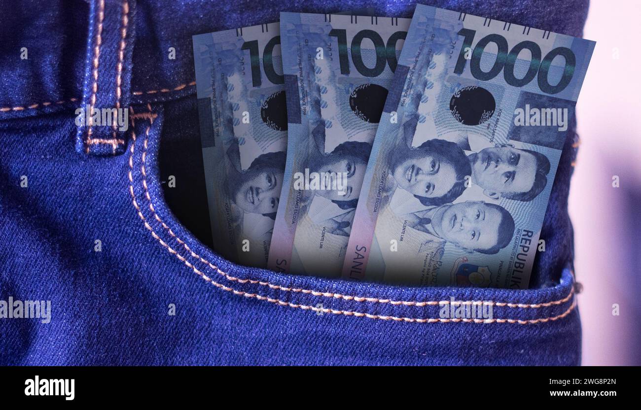 Bunch of 1000 Philippine Perso banknotes in a jeans pocket a concept of spending Stock Photo