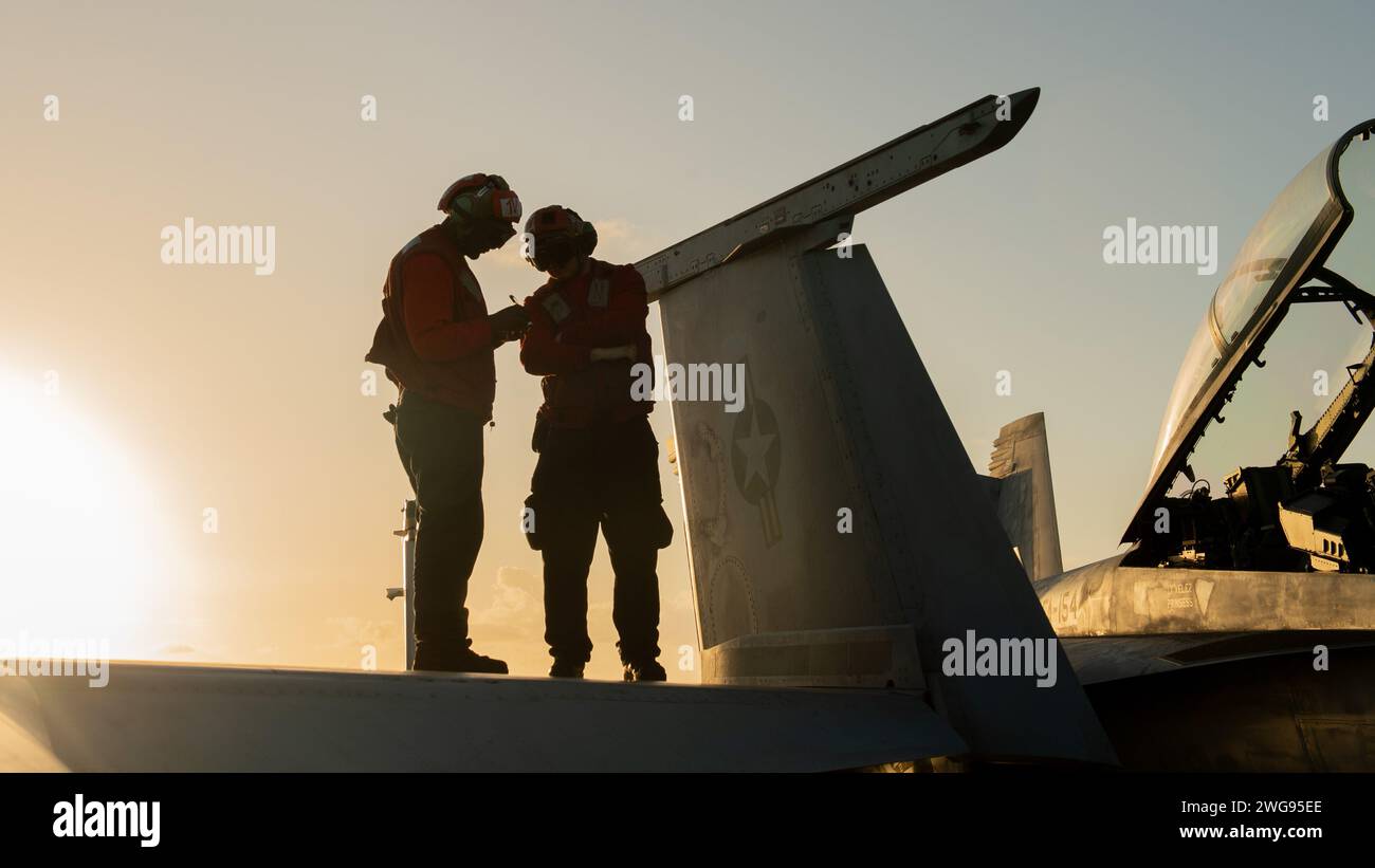 PHILIPPINE SEA (Feb. 2, 2024) U.S. Navy Aviation Ordnanceman Airman Didier Kakozi, from Kigoma, Tanzania, left, and U.S. Navy Aviation Ordnanceman Airman Demitrius James, from Salina, Kan., conduct maintenance on a F/A-18F Super Hornet, assigned to the “Black Knights” of Strike Fighter Squadron (VFA) 154, aboard the Nimitz-class aircraft carrier USS Theodore Roosevelt (CVN 71), Feb. 2, 2024. Theodore Roosevelt, flagship of Carrier Strike Group Nine, is underway conducting routine operations in the U.S. 7th Fleet area of operations. An integral part of U.S. Pacific Fleet, U.S. 7th Fleet operate Stock Photo