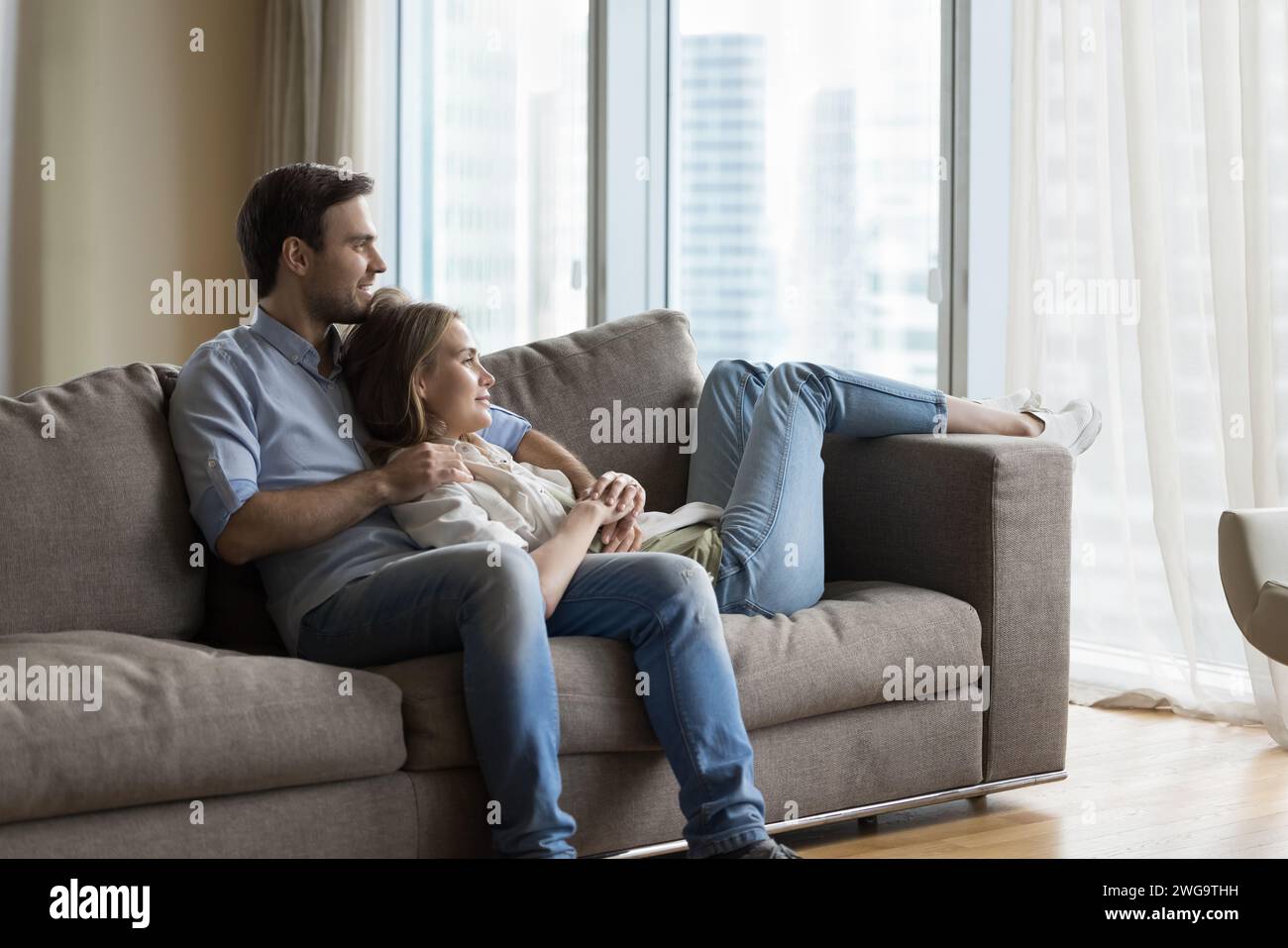 Peaceful couple in love daydreaming relaxing on sofa at home Stock Photo