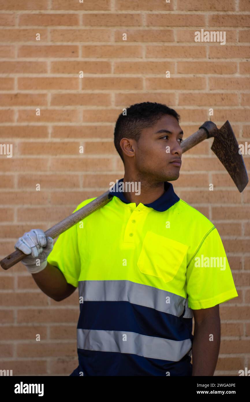 Portrait of a serious laborer with a hoe over his shoulder, vertical ...