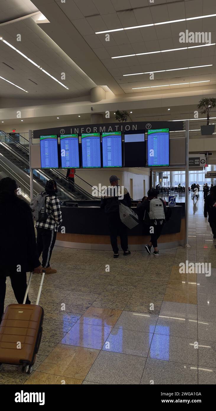 Atlanta, GA,USA: January 3,2024: Passengers checking the information counter for flight details at the busy international terminal of Hartsfield Jacks Stock Photo