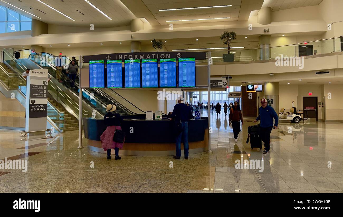 Atlanta, GA,USA: January 3,2024: Passengers checking the information counter for flight details at the busy international terminal of Hartsfield Jacks Stock Photo
