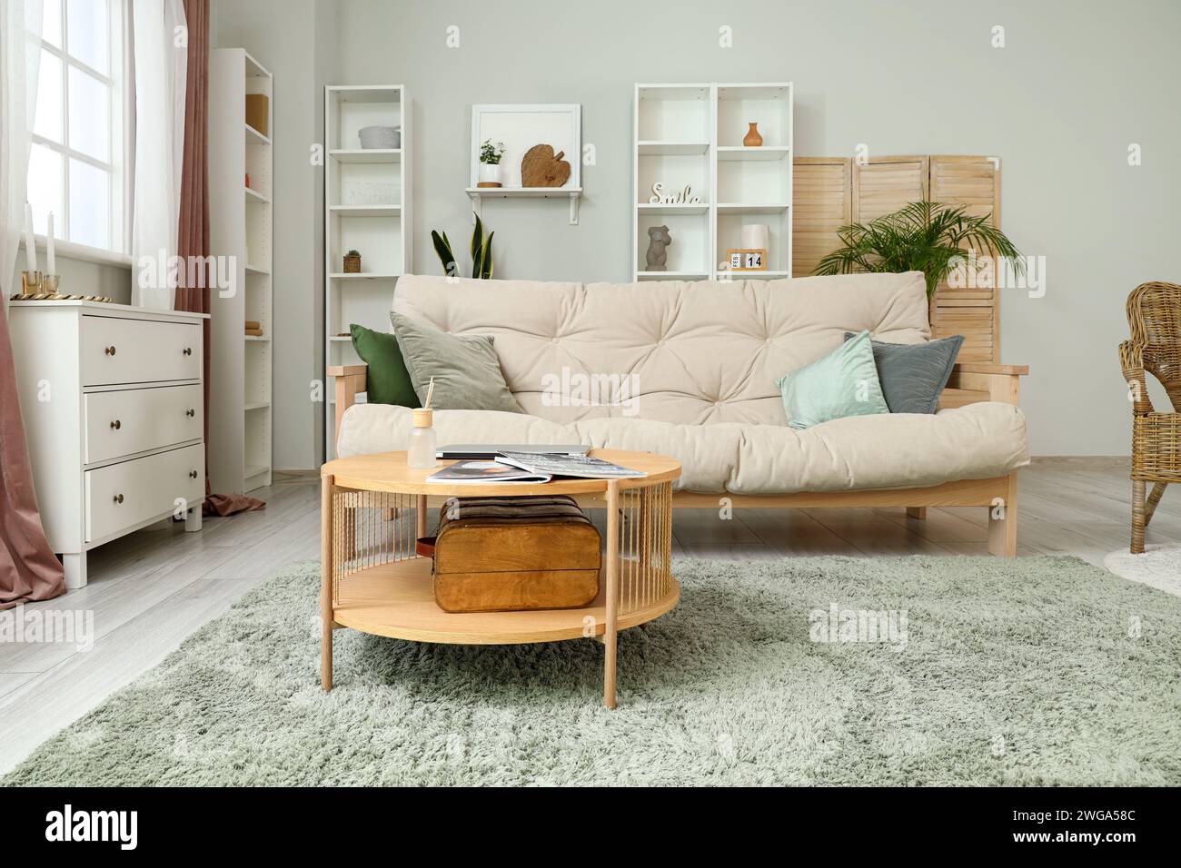 Interior of cozy living room with sofa, table and drawers Stock Photo ...