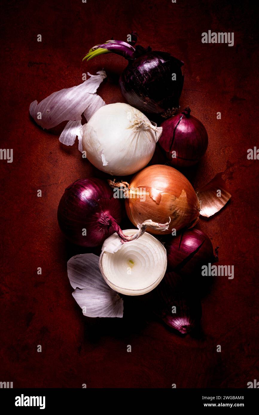 some red, white and golden onions on textured background with top view. Still life Stock Photo