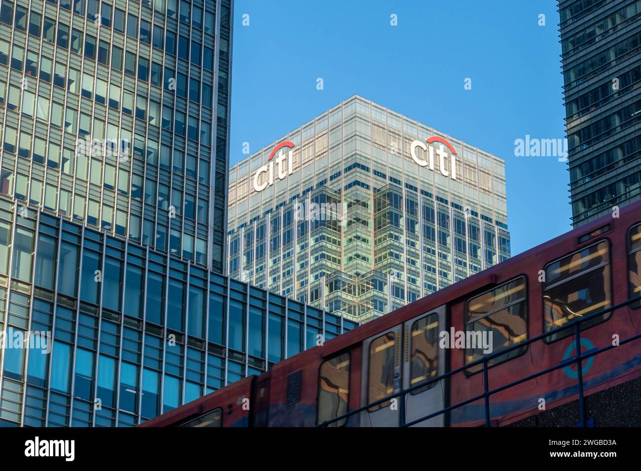 Canary Wharf skyscrapers including Citigroup HQ building (Citi sign and logo) with a DLR Docklands Light Railway train, East London, England, UK Stock Photo