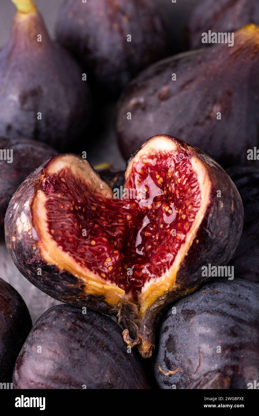 background with fresh and ripe figs, in the foreground an open fig ...