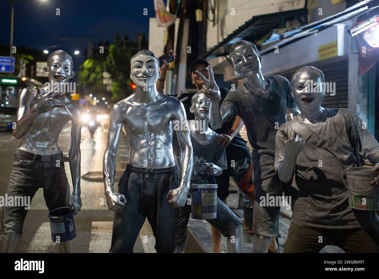 Jakarta, Indonesia - February 3, 2024: A group of unidentified young men with bodies painted silver seen on the streets of Jakarta, Indonesia. Stock Photo
