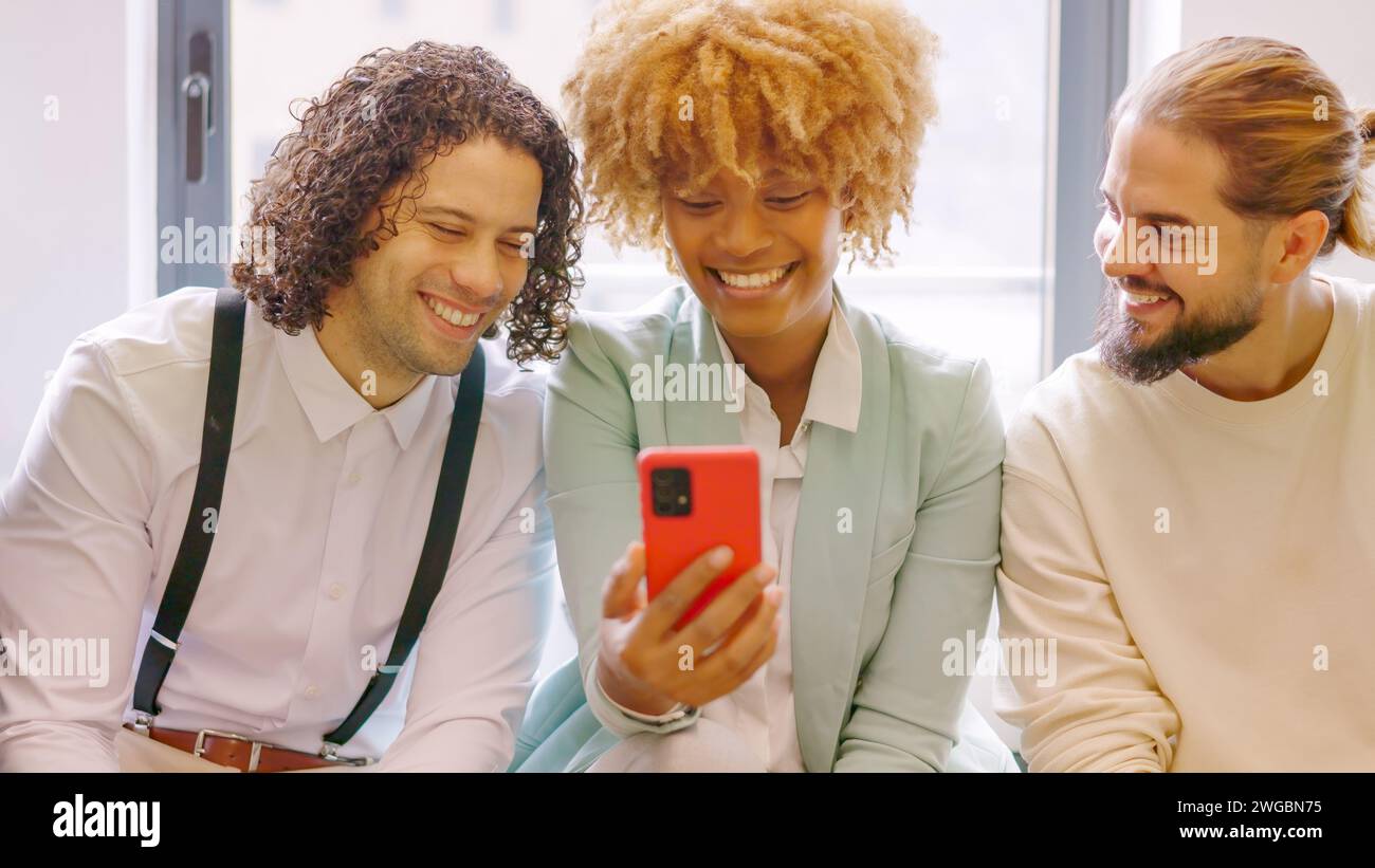 Coworkers using phone sitting relaxed during a break Stock Photo