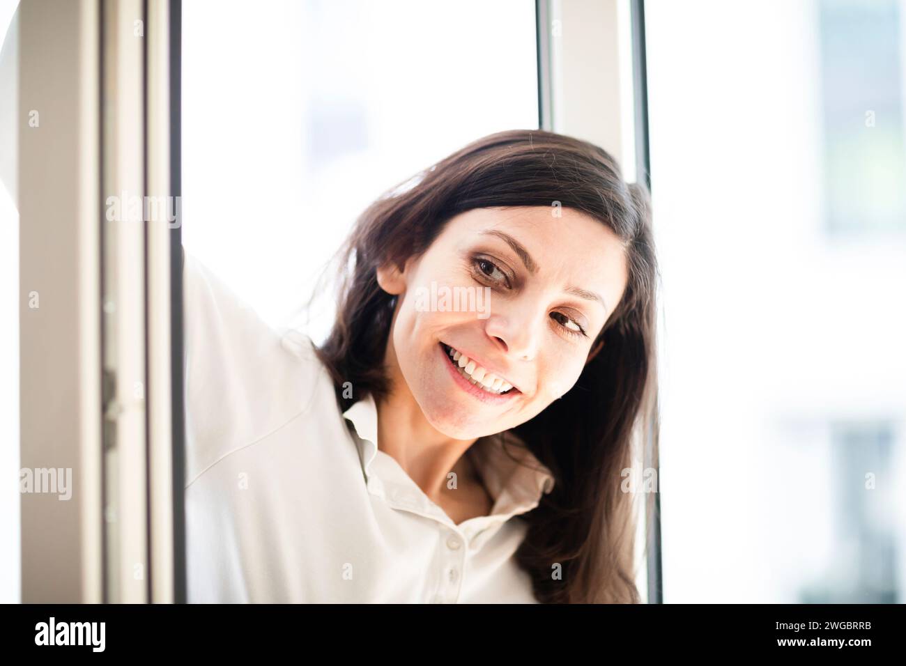 Portrait of a smiling woman standing in an open doorway Stock Photo - Alamy