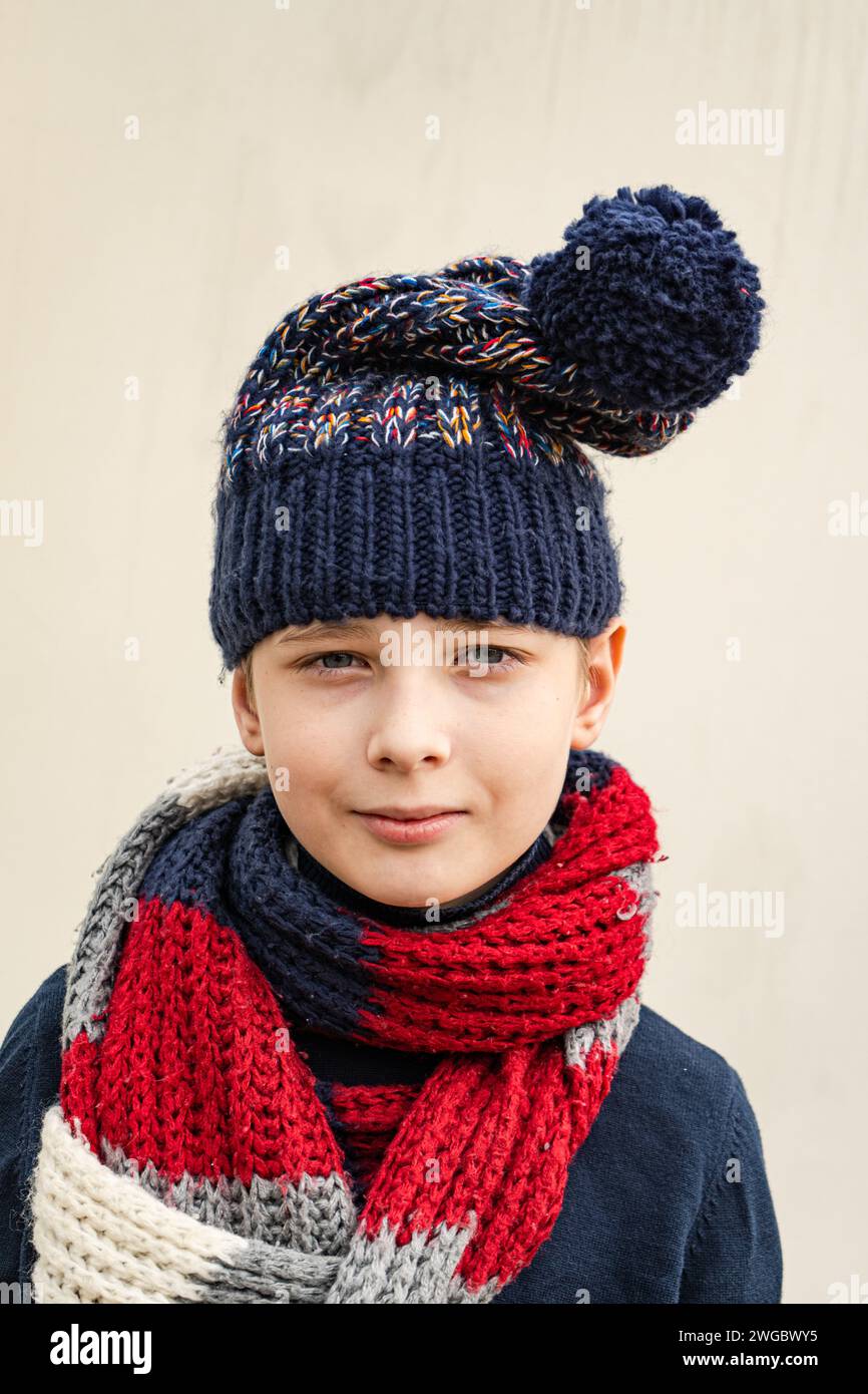 Portrait of a young boy wearing a woolly bobble hat and scarf Stock Photo