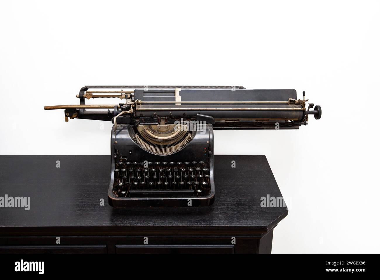 Antique typewriter on a desk isolated on white background. Stock Photo