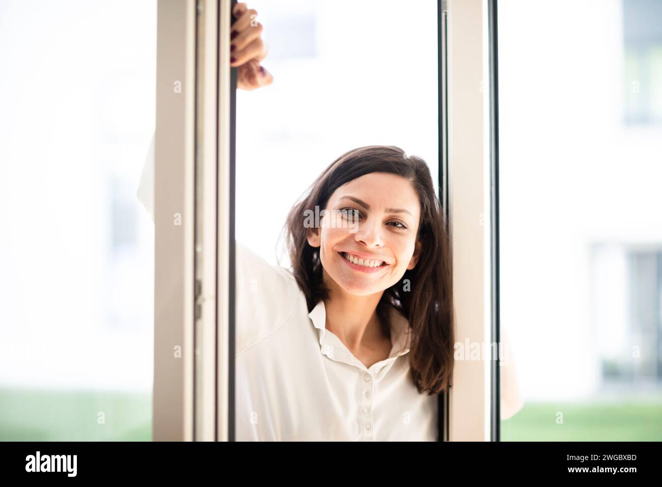 Portrait of a smiling woman standing in an open doorway Stock Photo - Alamy