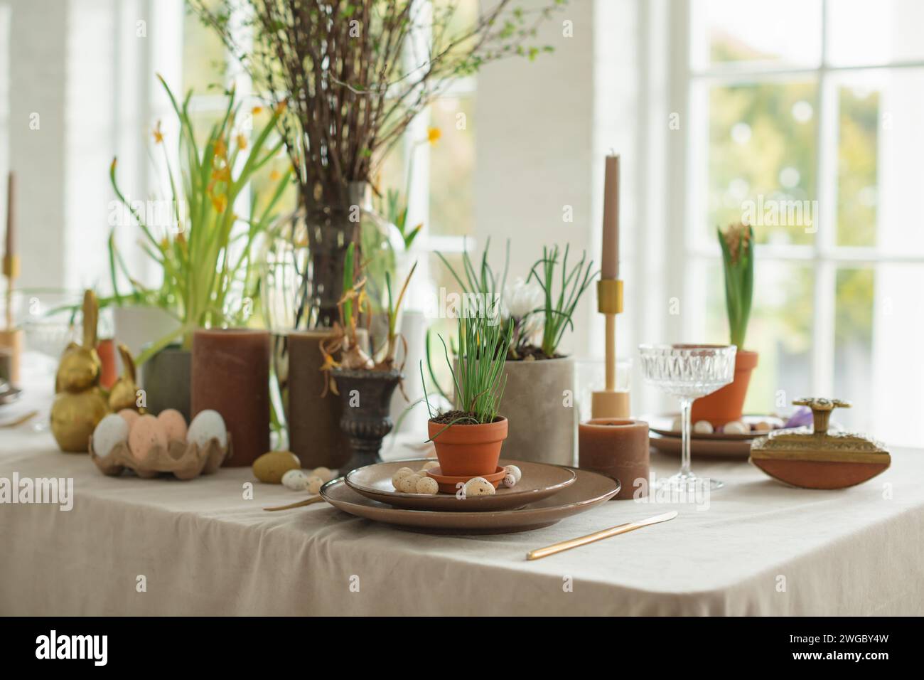 Festive Easter table setting with painted Easter eggs, spring flowers and candles Stock Photo