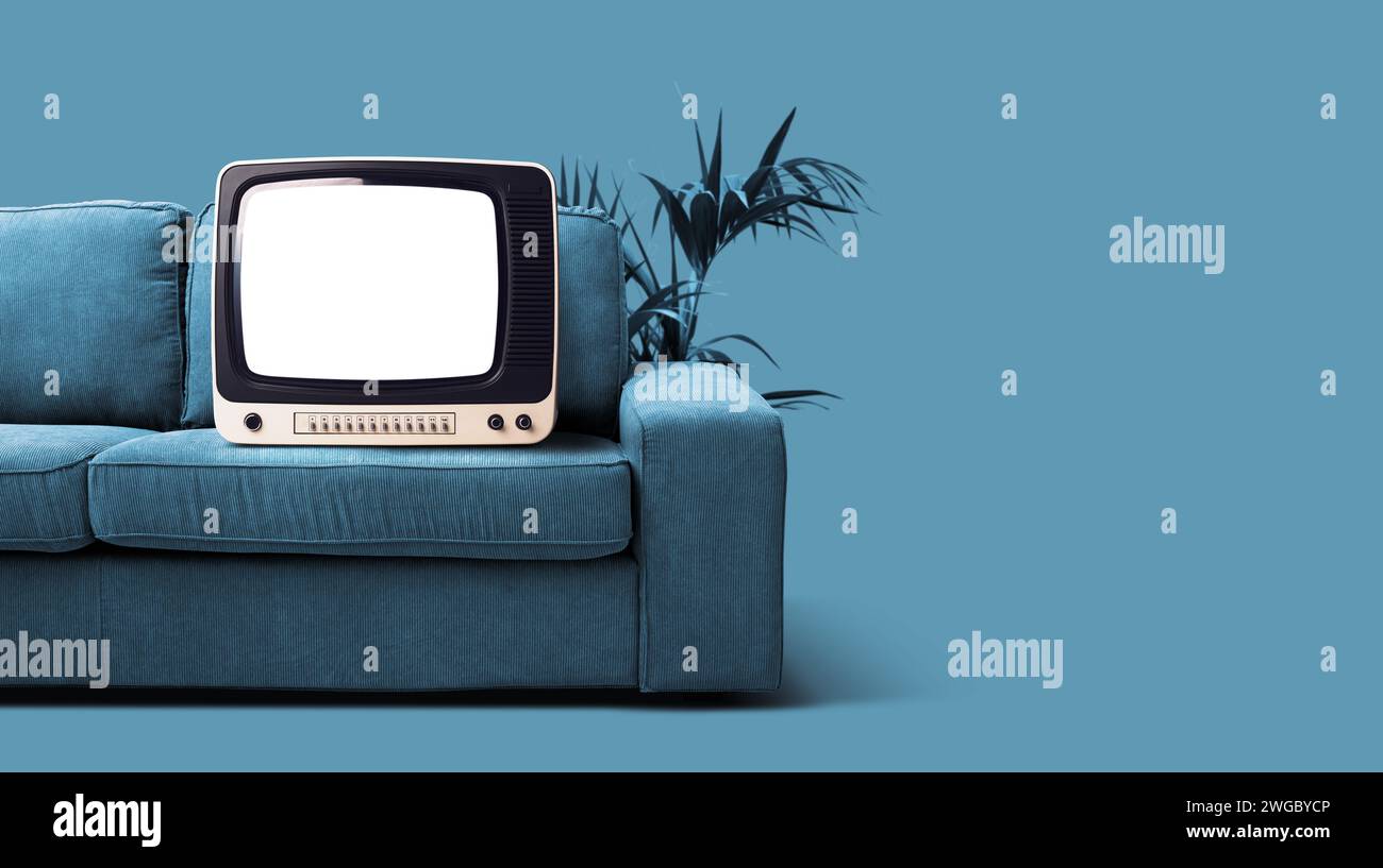 Old retro television with blank screen on the couch, entertainment and vintage appliances concept Stock Photo
