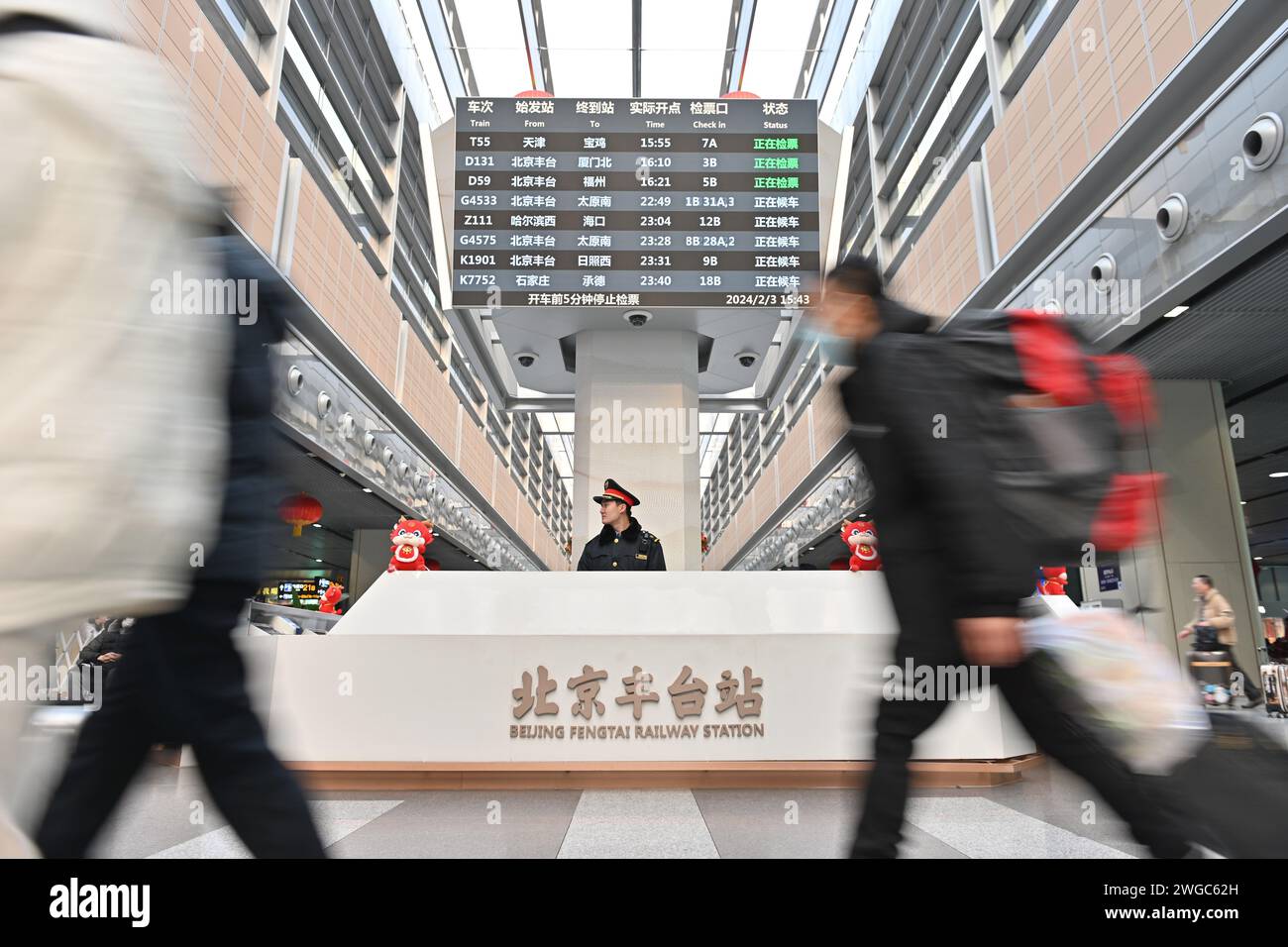 Beijing, China. 3rd Feb, 2024. Passengers walk past a service booth in Fengtai Railway Station in Beijing, capital of China, Feb. 3, 2024. Beijing Fengtai Station entered the peak of the passenger flow of Spring Festival travel rush. Credit: Song Weiwei/Xinhua/Alamy Live News Stock Photo