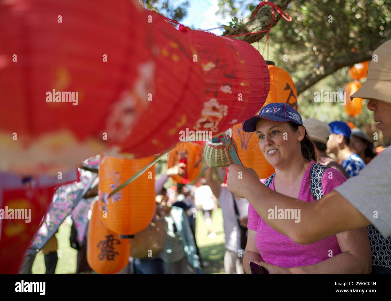 Auckland, New Zealand. 4th Feb, 2024. People look at traditional Chinese lanterns at the 'Happy Chinese New Year' Beach Carnival in Auckland, New Zealand, Feb. 4, 2024. The 'Happy Chinese New Year' Beach Carnival, co-hosted by the China Cultural Centre in Auckland and the Asian Community Engagement Trust, was held at the Mission Bay Beach in Auckland on Sunday. Credit: Zhao Gang/Xinhua/Alamy Live News Stock Photo