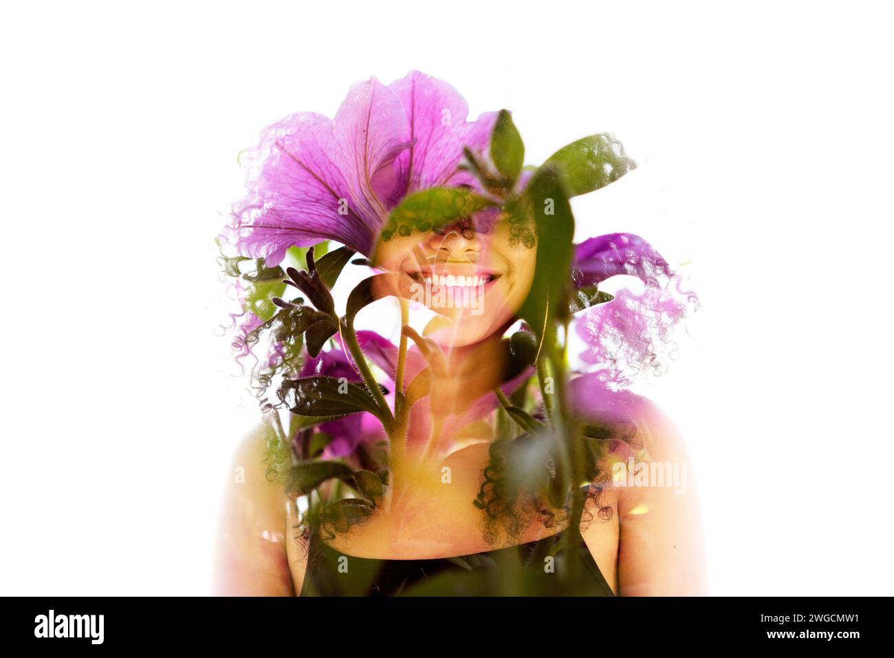 A double exposure portrait of a smiling woman merged with pink flowers ...