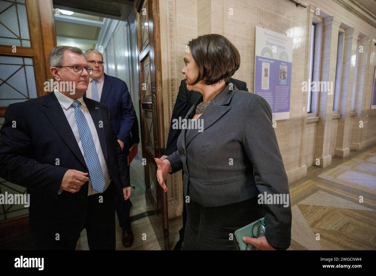 Sinn Fein President Mary Lou McDonald (right) passes DUP leader Sir Jeffrey Donaldson MP (left) and DUP deputy leader Gavin Robinson MP (second from left) in the corridor at the entrance to the public gallery of a he Northern Ireland Assembly Chamber. Picture date: Saturday February 3, 2024. Stock Photo