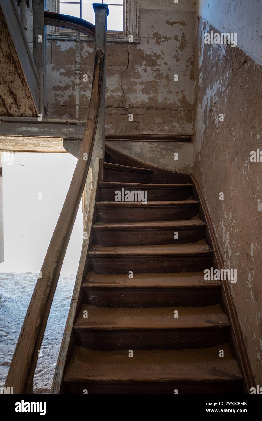 The old wooden staircase in an abandoned building in an old desert town Stock Photo