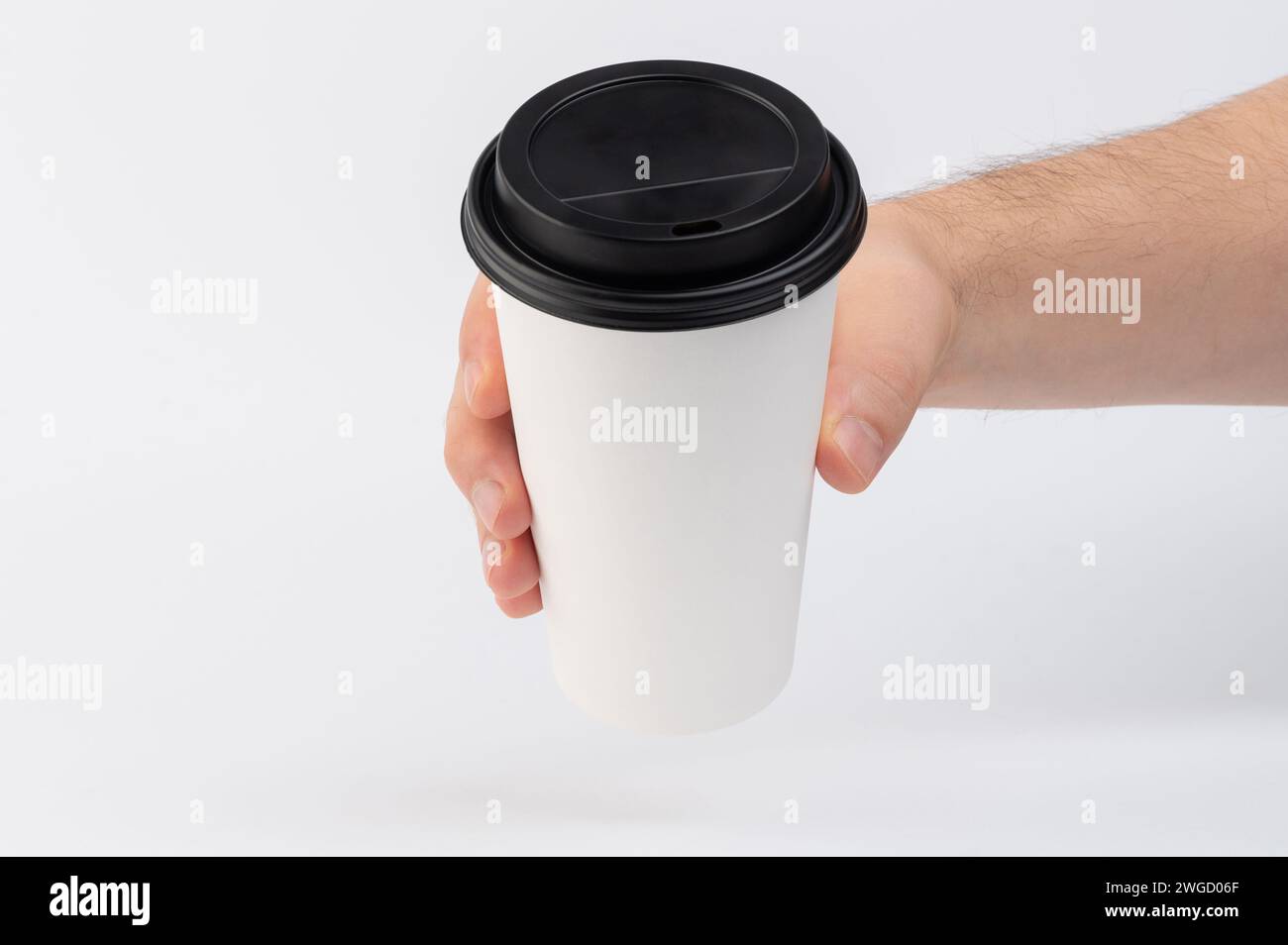 Hand hold white paper cup with lid cap isolated on white studio ...