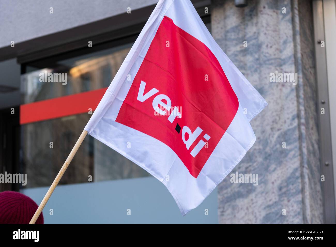 Augsburg, Bavaria, Germany - February 3, 2024: Demonstrator with a flag with the ver.di logo at a demonstration *** Demonstrant mit einer Fahne mit dem ver.di Logo bei einer Demo Stock Photo