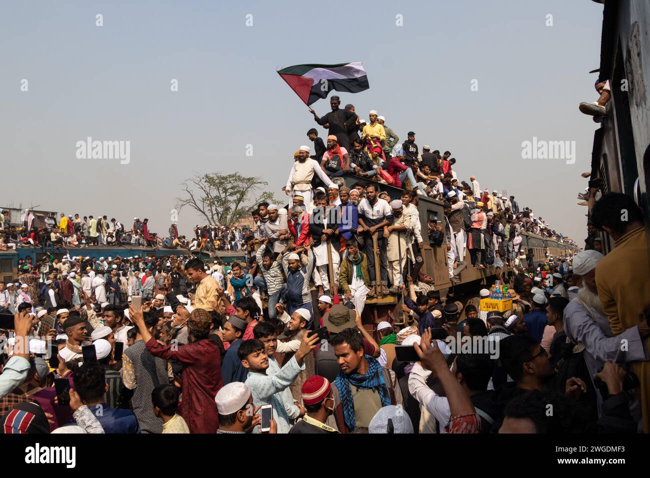 Tongi, Dhaka, Bangladesh. 4th Feb, 2024. Muslim devotees travel by overcrowded risky trains after attending the Akheri Munajat (final prayer) at the Biswa Ijtema in Tongi, Dhaka, Bangladesh. Locals tackle the journey by climbing on, clinging to, and clambering along the roofs of locomotives. With no seats available inside, many commuters decide to take the risk and choose a rooftop view for their journey out of Dhaka city. Credit: ZUMA Press, Inc./Alamy Live News Stock Photo