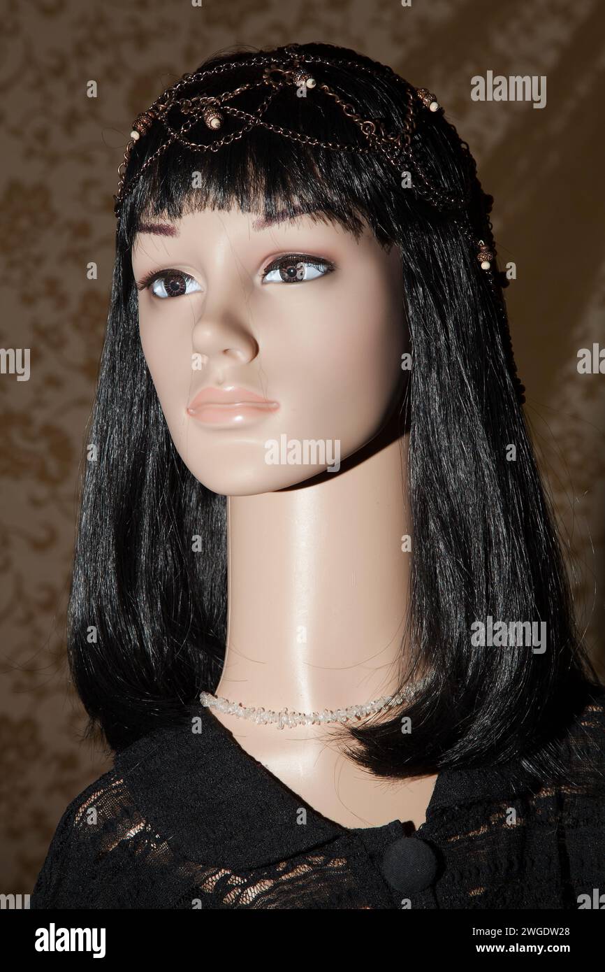Plastic woman mannequin with black long hair wearing a black lace top