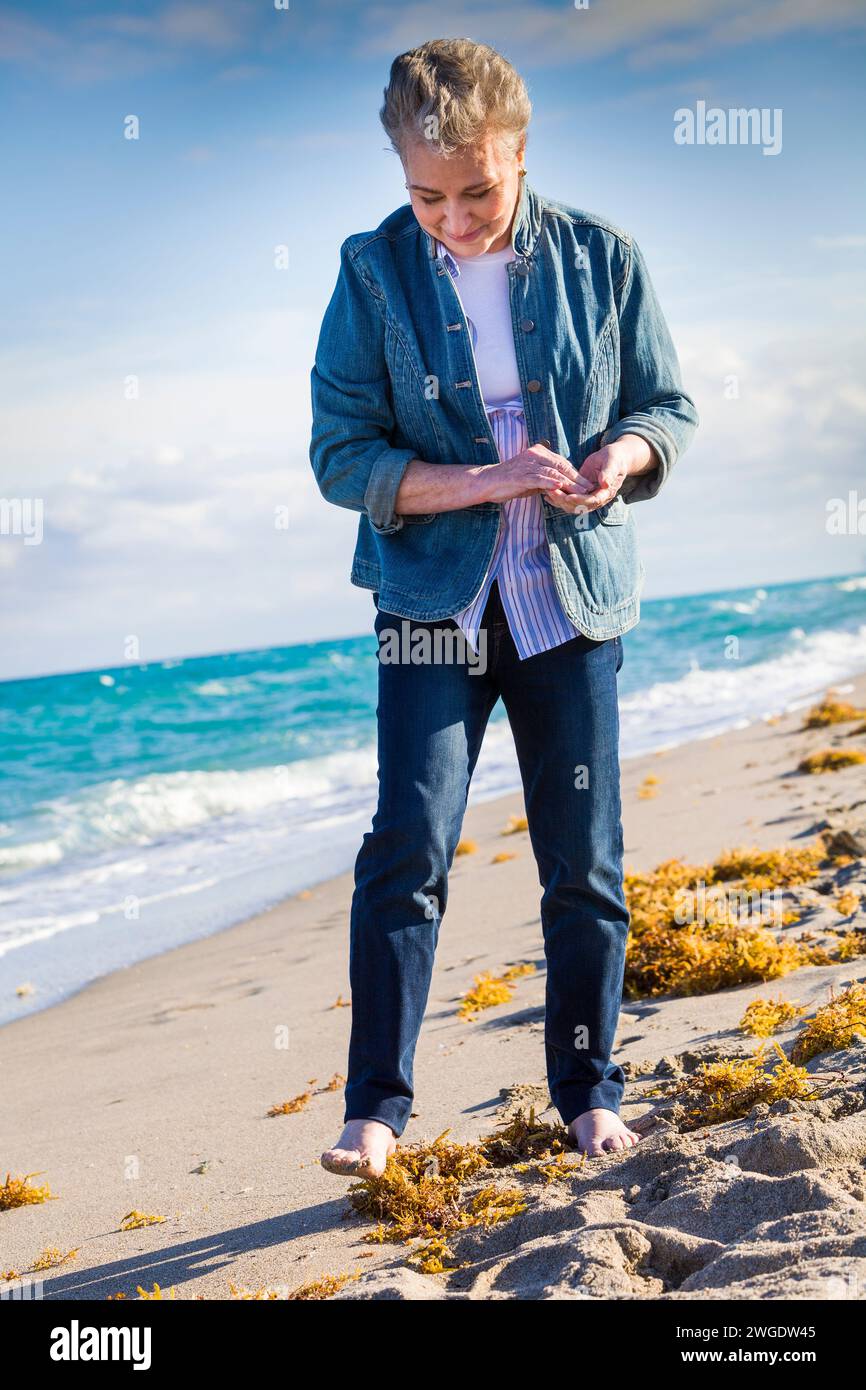 Senior woman walking on the beach, Dania Beach, Florida, USA Stock Photo