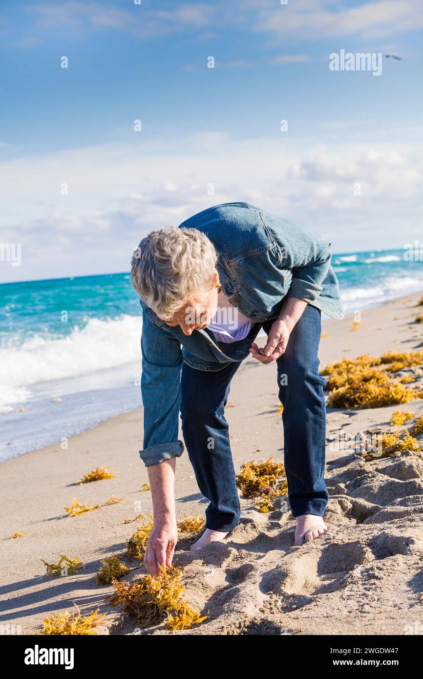 Senior woman walking on the beach, Dania Beach, Florida, USA Stock Photo