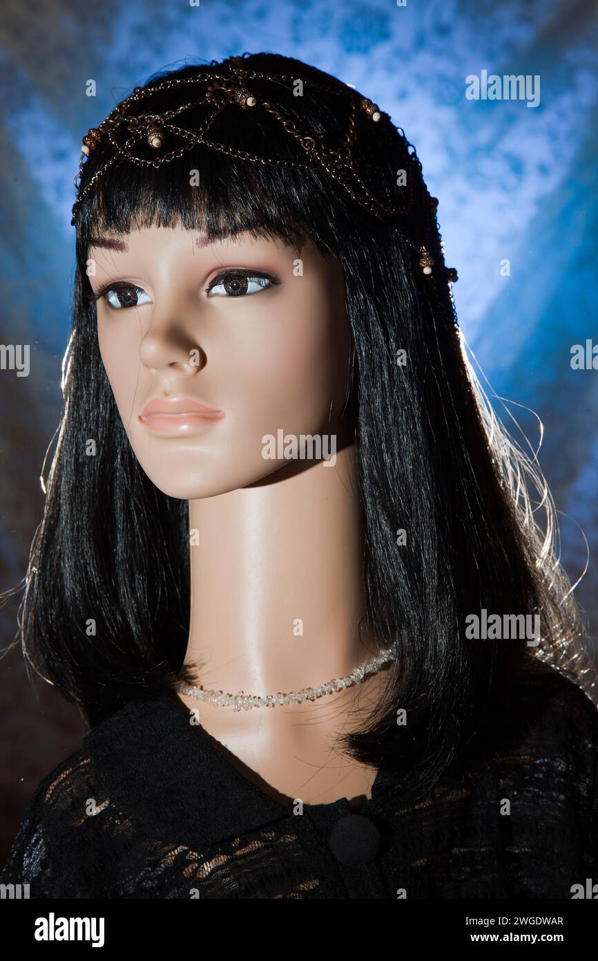 Plastic woman mannequin with black long hair wearing a black lace top