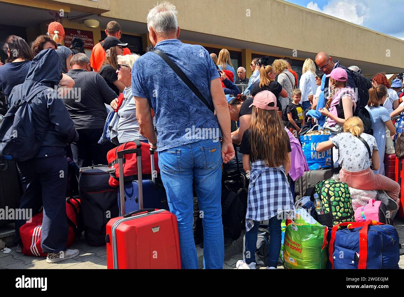 People are standing on platform, passengers with suitcases and bags. Ukrainian refugees wait for train in Polish city of Przemysl, Poland 2022-06-17 Stock Photo