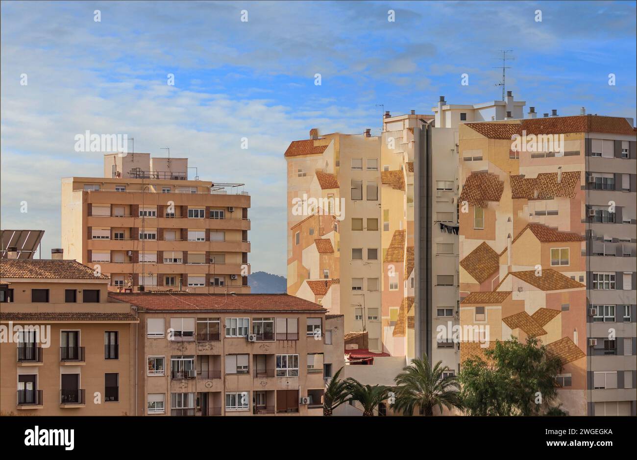 Unique wall art on the side of tower blocks depicting the rooftops of a small town Stock Photo