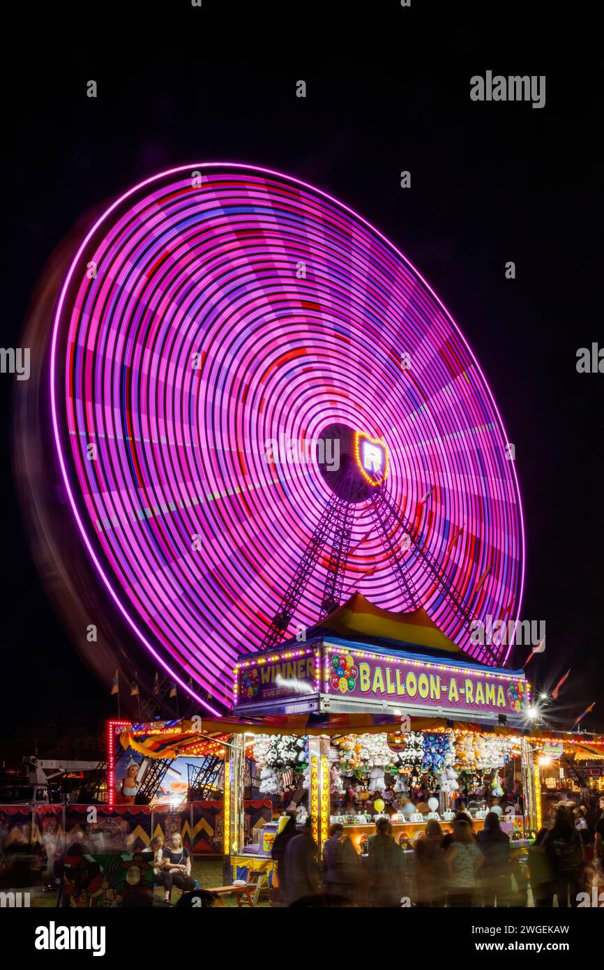 Dutch Wheel. Ferris Wheel. Carnival Ride with long exposure motion blur. Balloon-A-Rama carnival game tent in foreground. Canfield Fair, Mahoning Coun Stock Photo