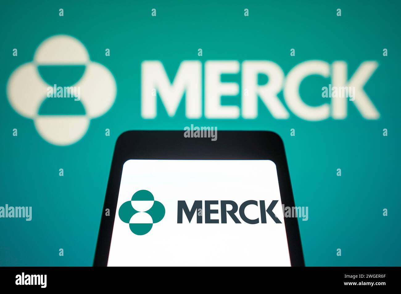 In this photo illustration, the Merck Sharp and Dohme logo is displayed on a smartphone screen and in the background. Stock Photo