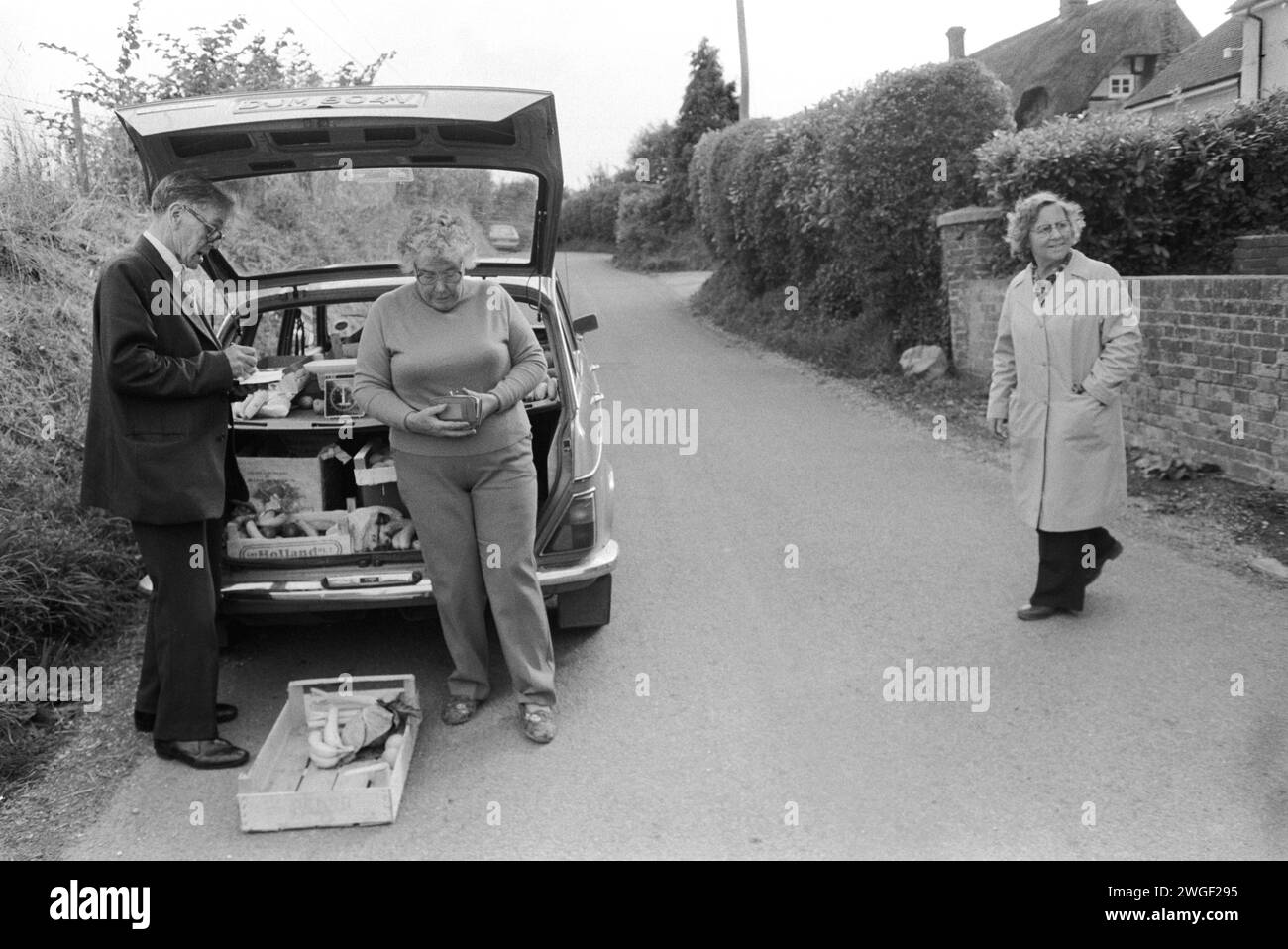 Grocery shopping mobile shop 1980s UK. The local Methodist lay preacher deliveries pre-ordered groceries once a week from the back of his car. The village shop had recently closed down.1980s Britain rural community grocery shopping Upper Basildon Berkshire England  1983  1980s  UK HOMER SYKES Stock Photo