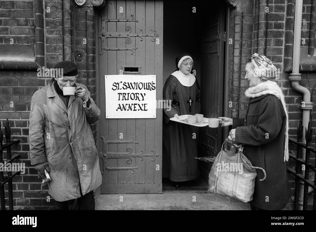 Homeless destitute 1970s UK. Sister Patricia hands out cups of tea from St Saviour's Priory annex, Kingsland Road, London. The Sisters of St Margaret, explore contemporary ways of living the religious life in the community through a balance of prayer and ministry amongst marginalised groups; the homeless, alcoholics, and racial minorities who are in need. Hoxton, London, England 1978. HOMER SYKES Stock Photo