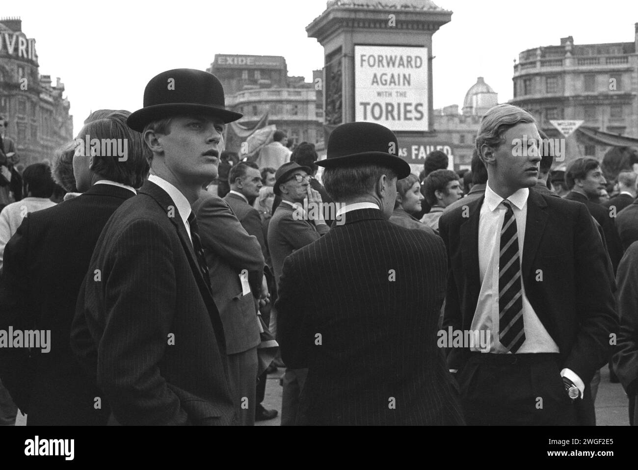 Young Conservatives, at political rally Trafalgar Square, London 1960s UK.  Bowler hatted, suited and wearing their old school ties, four young  ‘City Gents’ attend a Conservative Party ‘Forward Again with the Tories’ rally in the run up to the 1970 General Election. England 1969. HOMER SYKES Stock Photo