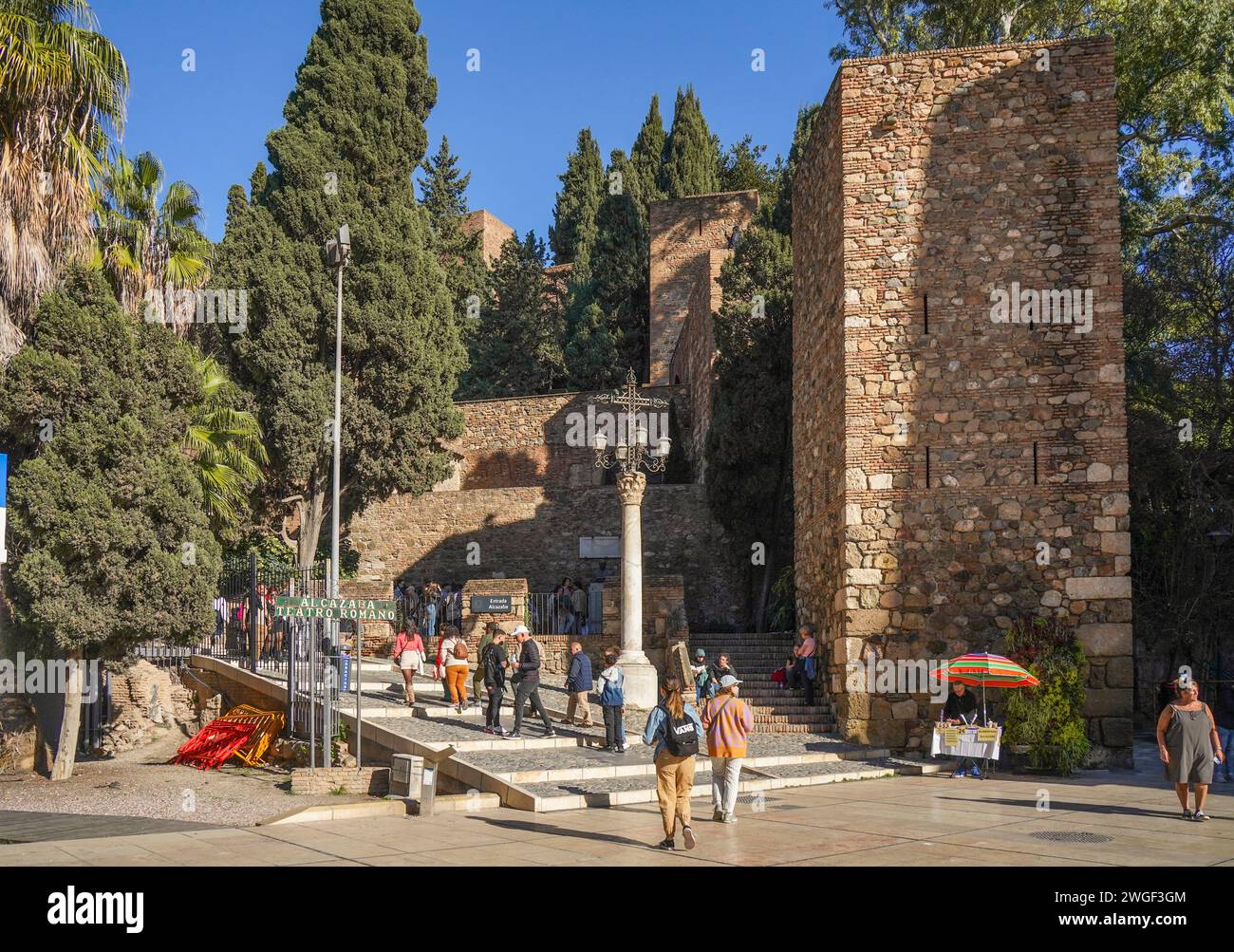 Young tourists in front of the entrance of Malaga Alcazaba. Ancient Moorish Alcazaba castle, Malaga, Andalusia, Spain. Stock Photo