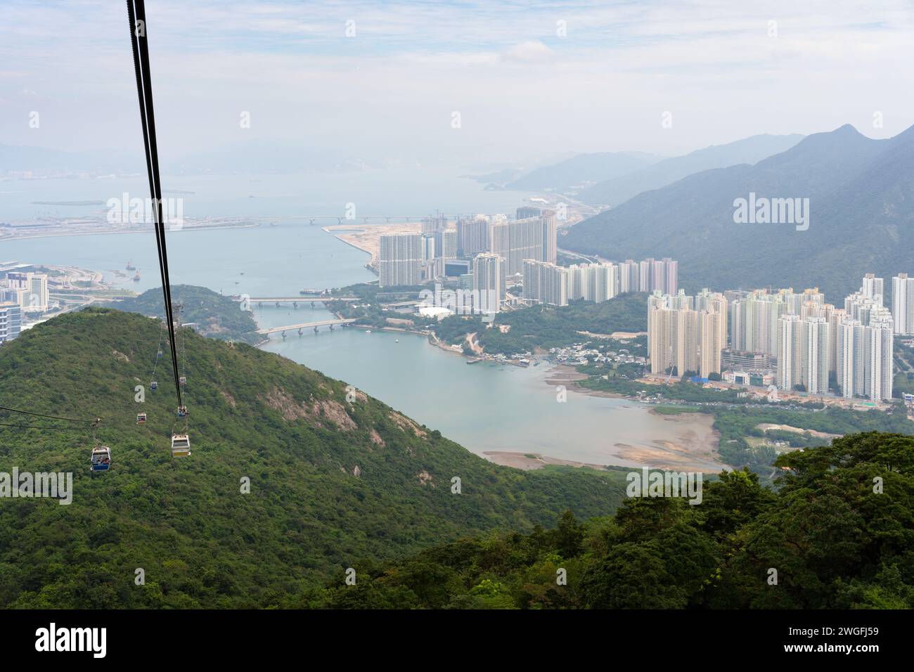 Mountain side view with city in background and gondola ride Stock Photo