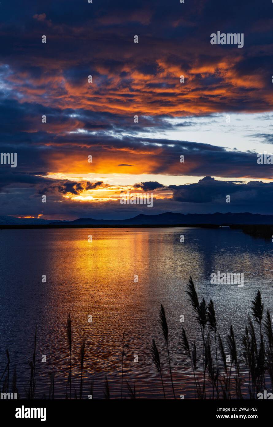 The setting sun lights up the clouds in the Turpin Unit of Farmington Bay Waterfowl Management Area, Farmington, Davis County, Utah, USA. Stock Photo