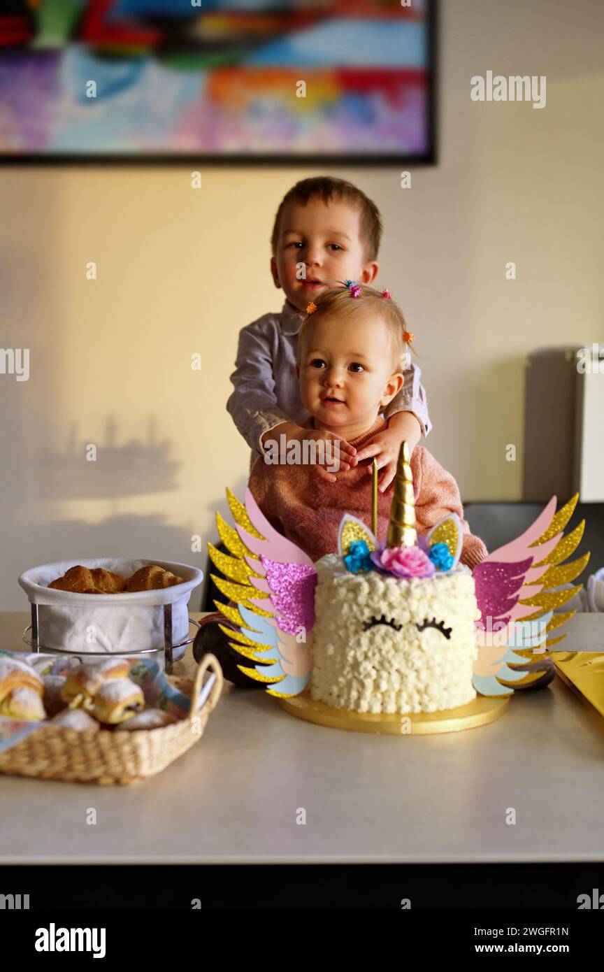 Little brother and sister in front  of her birthday cake Stock Photo