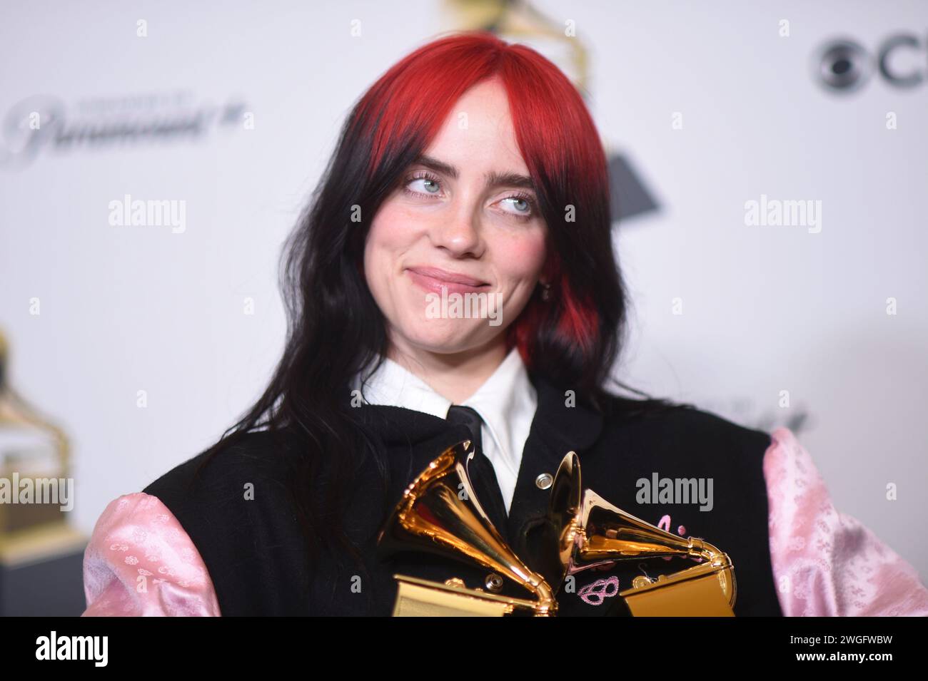 Billie Eilish poses in the press room with the awards for best song