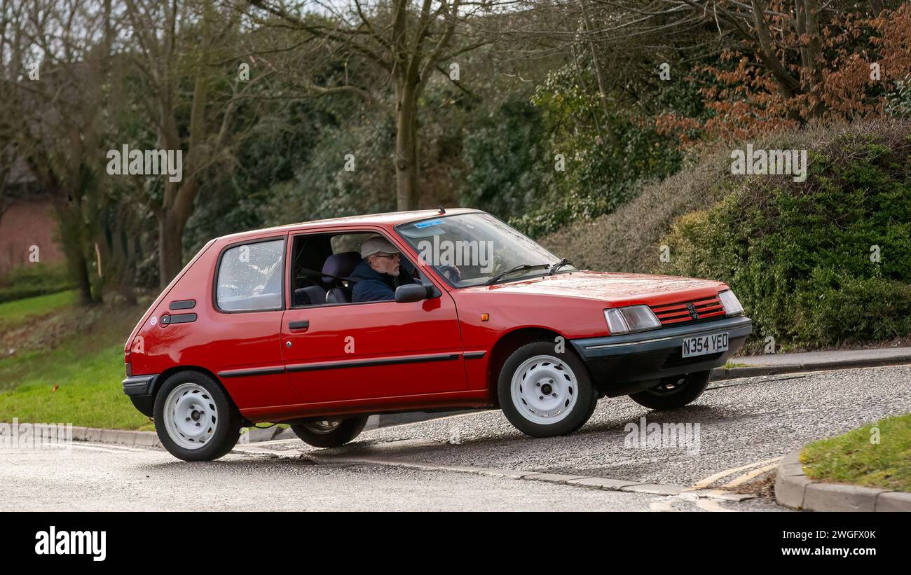 Milton Keynes,UK-Feb 4th 2024: 1996 red Peugeot 205 diesel engine  classic car  driving on an English road. Stock Photo