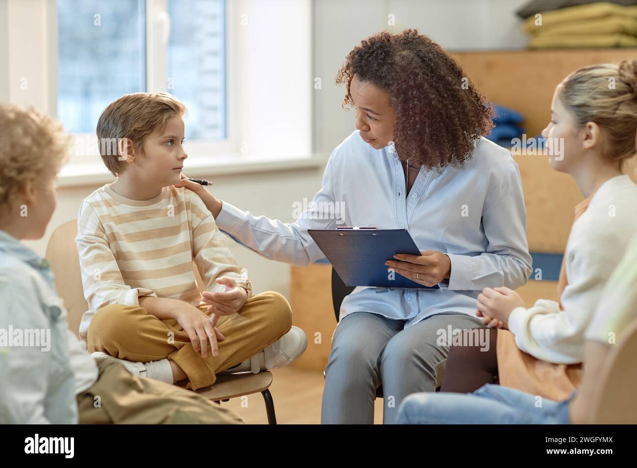 Side view portrait of young female psychologist comforting boy in