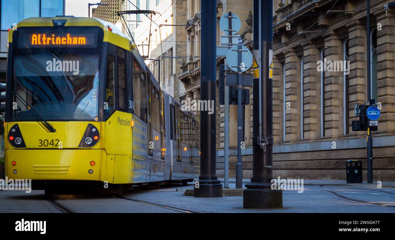 A vibrant yellow tram in the streets of Manchester, UK. Stock Photo